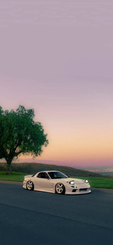 White Sports Car under the Setting Sun Phone Wallpaper