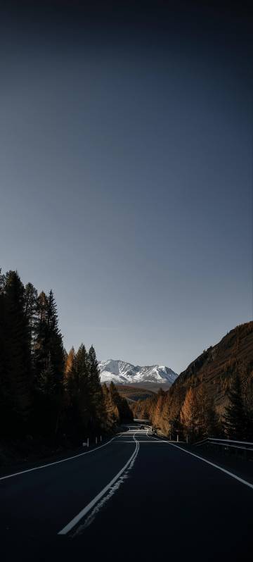 Phone wallpapers: roads, snowy mountains, forests, gray skies