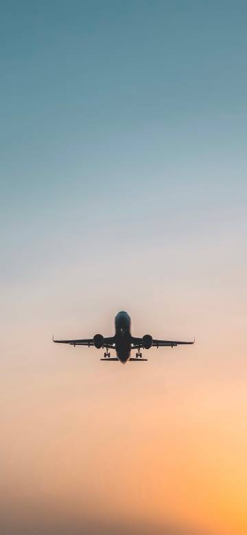 Airplane Taking Off into Sunset Sky Wallpaper