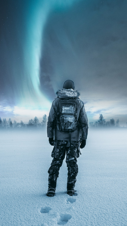 Man Watching Northern Lights in Snowfield 4K Wallpaper