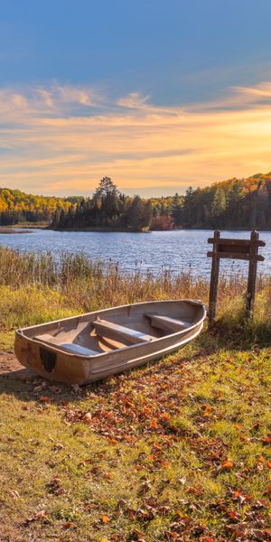 Tranquil Autumn Lake Scene with Boat and Vibrant Trees