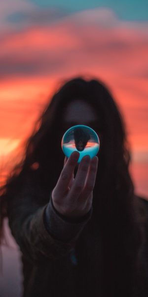 Aesthetic Girl Holding a Crystal Ball with a Beautiful Sunset Reflection