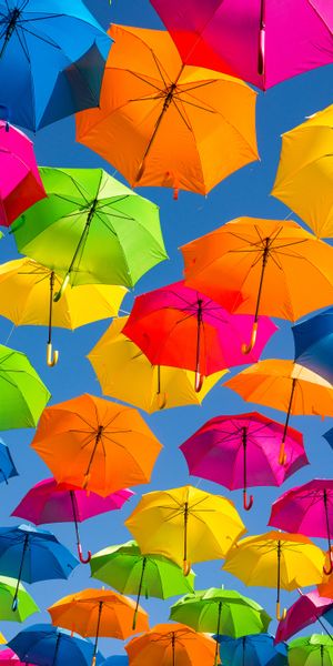 Colorful Umbrellas in a Bright Sky: A Cheerful Phone Wallpaper