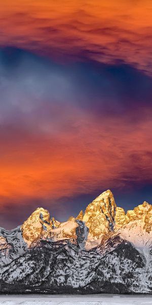 HD iPhone Wallpaper: Majestic Snow-Capped Mountains Under a Fiery Sky