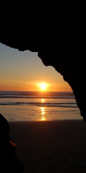 Breathtaking Cave Beach Sunset Wallpaper: Ocean and Earth Unite