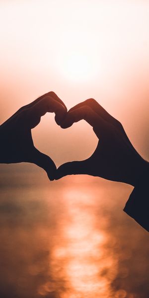 Heart-Shaped Hands Framing a Sunset