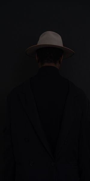 Mysterious Dark Wallpaper with a Stylish Figure in a Hat