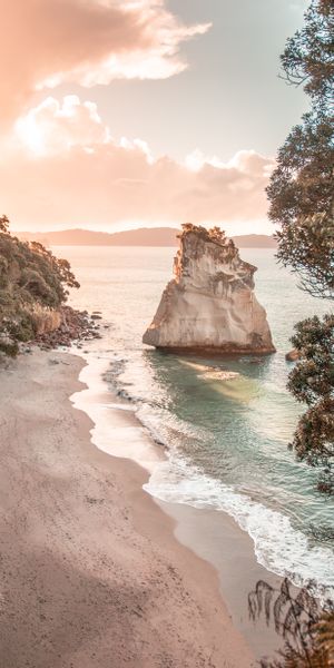 Serene Beach Scene with Rocky Outcrop and Gentle Waves