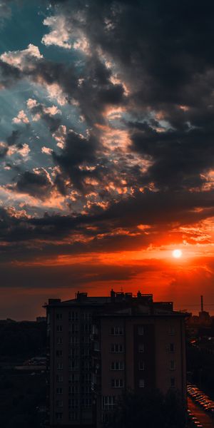 Dramatic Sunset Over Urban Skyline with Colorful Clouds