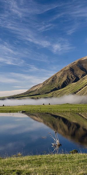 Breathtaking HD phone wallpaper of a tranquil farm scene with mountains and water