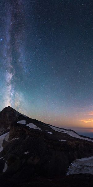Breathtaking View of Meteor Shower and Snowy Mountains at Dusk