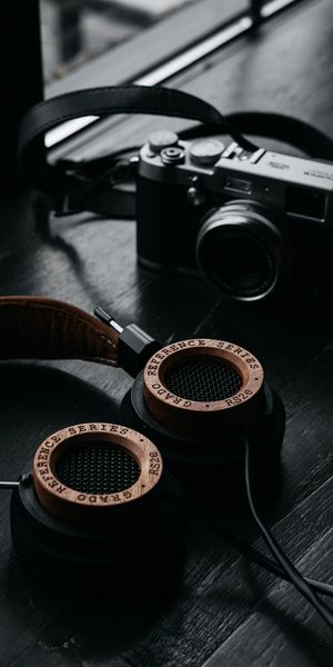 Stylish Retro Headphones and Camera on Dark Wood Table