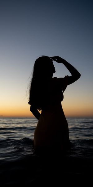 Silhouette of a Girl in the Sea at Sunset