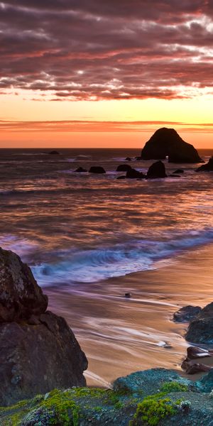 Breathtaking coastal sunset wallpaper with ocean waves and rocky shoreline