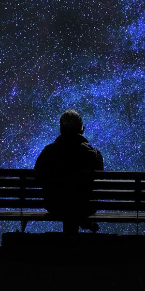 Lonely Man on a Bench Gazing at the Starry Night Sky