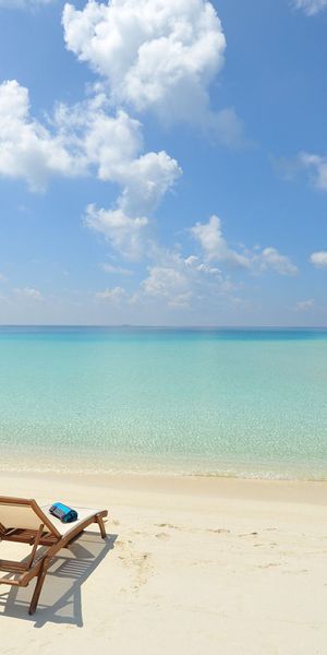 Relaxing Beach Scene with Chairs and Bungalows