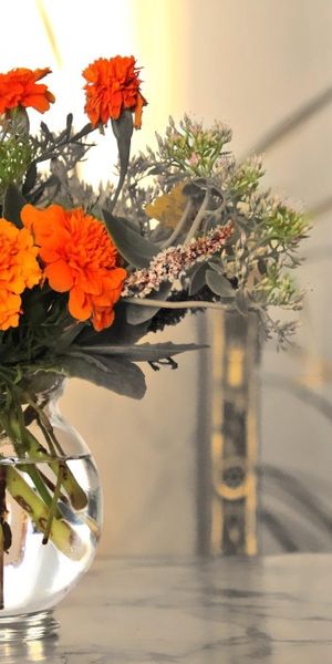 Beautiful Orange Flower Arrangement in a Glass Vase on Marble Table