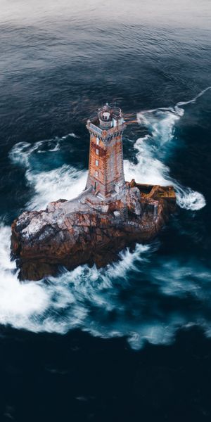 Aerial View of a Majestic Lighthouse on Rocky Island