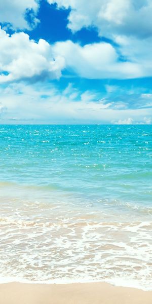 Beautiful Turquoise Beach with Clear Sky and Soft Clouds