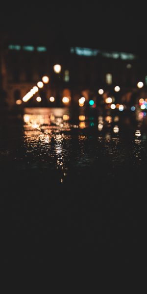 Captivating Night Scene with Reflections on Wet Asphalt