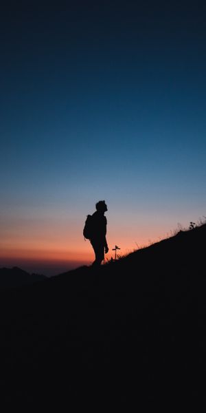 Lonely Journey: Silhouette on a Mountain at Night