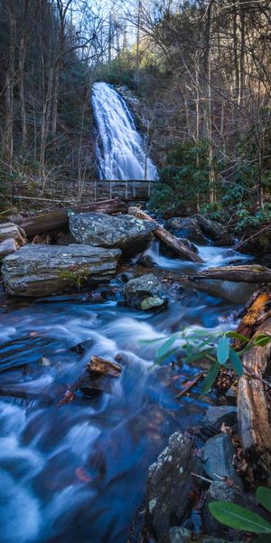Breathtaking Waterfall Surrounded by Lush Trees and Flowing River