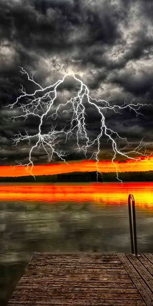 Breathtaking Ultra HD mobile wallpaper featuring a sunset and lightning over a lake