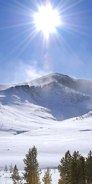 Breathtaking mountain scenery phone wallpaper featuring a radiant sun