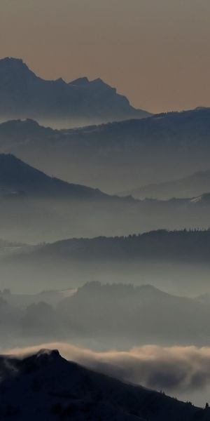 Breathtaking mountain landscape phone wallpaper featuring misty peaks