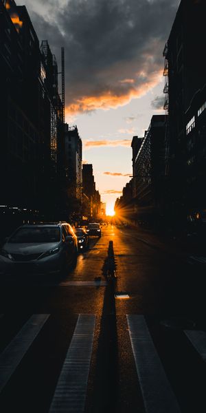 Captivating HD wallpaper featuring a city street at sunset with rays of light