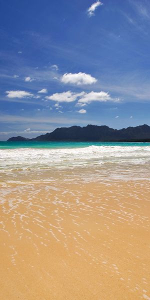 Breathtaking 4K iPhone Wallpaper: Tranquil Beach with Waves and Clouds