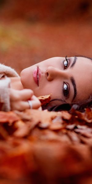Phone wallpaper: Blur, Leaf, Fall, Brunette, Model, Women, Brown Eyes, Lying Down free download