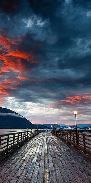 Breathtaking 4K phone wallpaper of a wharf at sunset with ocean views