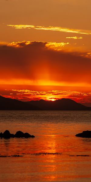 Beautiful Sunset Over the Sea with Hills and Stones