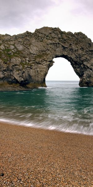 Durdle Door Beach Wallpaper: A Serene Coastal Landscape with Cliffs