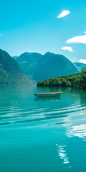 Serene Lake View with a Lonely Boat and Stunning Mountains