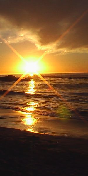 Breathtaking Beach Sunset Mobile Wallpaper: Ocean Waves and Golden Horizon