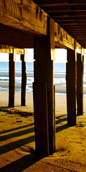 Serene beach wallpaper showcasing ocean waves beneath a wooden pier