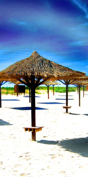 Beautiful beach wallpaper featuring thatched umbrellas and serene sands