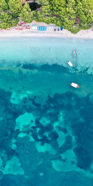 Aerial Beach View: Crystal Clear Waters and Lush Coastline
