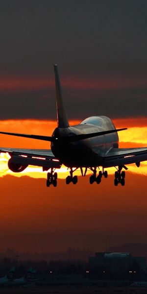 Breathtaking 4K mobile wallpaper of an airplane flying at sunset