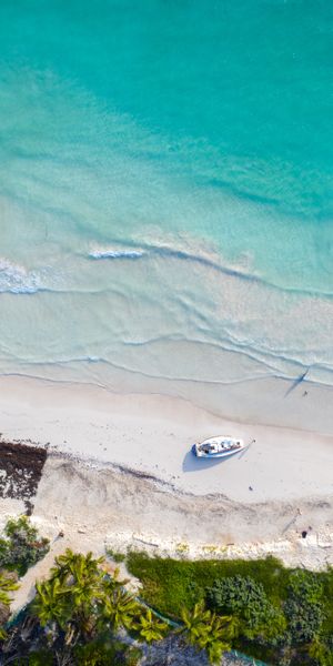 Breathtaking Aerial Beach View with Boat and Lush Tropical Trees