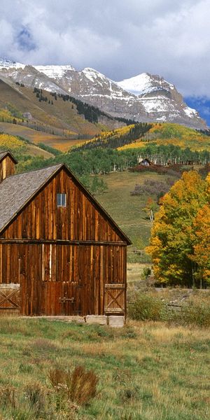 Breathtaking 4K phone wallpaper featuring mountains and a rustic barn
