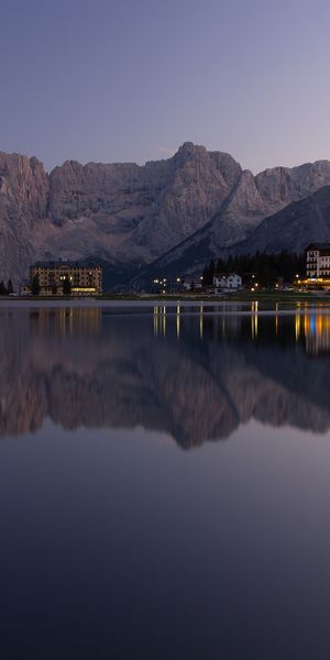 Breathtaking mobile wallpaper of a tranquil lake reflecting mountains at sunset
