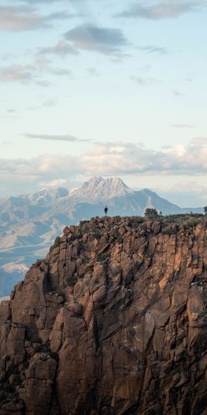 Lonely Hiker on a Majestic Mountain Cliff