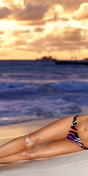 Beautiful iPhone wallpaper of a model on the beach at sunset