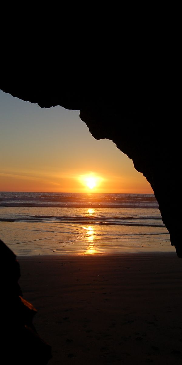Breathtaking Cave Beach Sunset Wallpaper: Ocean and Earth Unite