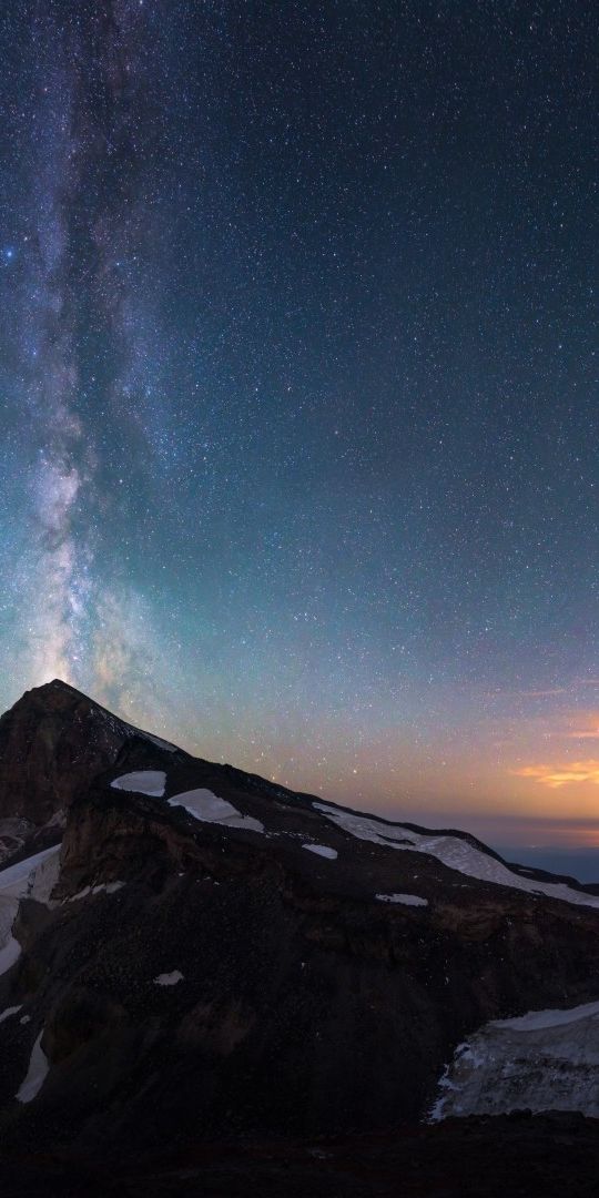 Breathtaking View of Meteor Shower and Snowy Mountains at Dusk