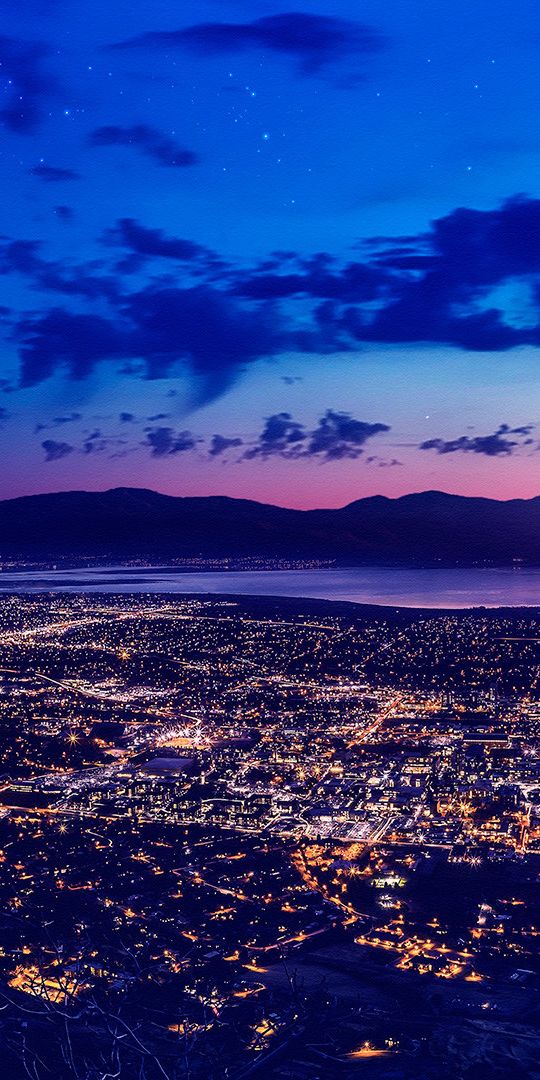 Enchanting Night Cityscape with Crescent Moon and Mountains - Phone Wallpaper