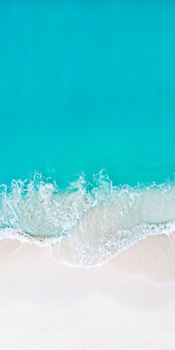 Aerial View of a Tropical Beach with Clear Blue Waves